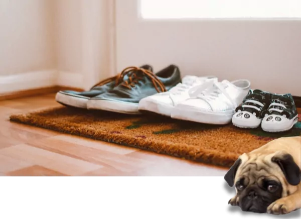 Dekoratives Bild mit Schuhen vor einer Haustür